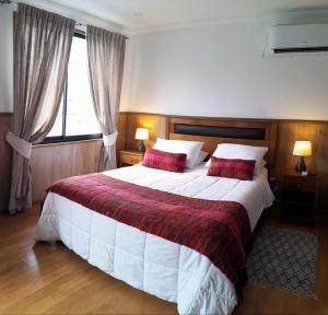 a bedroom with a large bed and a window at Hotel y Cabañas La Magia del Sur in Valdivia