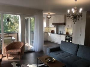 a living room with a couch and a kitchen at Thermal Forest Apartment in Kiskunhalas