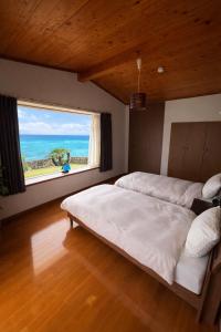 a bedroom with two beds and a large window at 478 retreat in Yoron