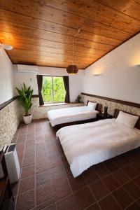 two beds in a room with wooden ceilings at 478 retreat in Yoron +7 photos