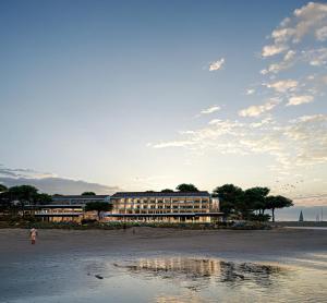 a hotel on the beach with a reflection in the water at Bel Hôtel Oléron Thalasso & Spa - MGallery Collection in Saint-Trojan-les-Bains