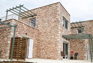 a brick building with two chairs in front of it at Stone Bay Houses in Messinia Kalamaki Beach Area in Chrani