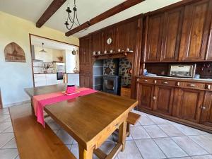 eine Küche mit einem Holztisch, auf dem eine rosa Serviette liegt in der Unterkunft Celles - Demeure de la Tourille in Celles