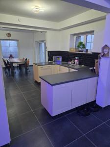 a large kitchen with purple cabinets and a table at Le Marronnier in Bastogne