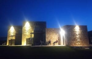 two people standing in front of a building at night at Stone Bay Houses in Messinia Kalamaki Beach Area in Chrani