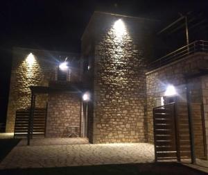 a brick building with lights on it at night at Stone Bay Houses in Messinia Kalamaki Beach Area in Chrani