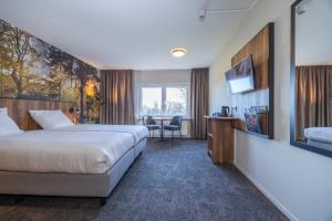 a hotel room with a bed and a television at Fletcher Hotel-Restaurant Paasberg in Lochem +55 photos