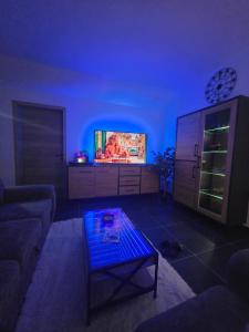a living room with a couch and a tv at Le Marronnier in Bastogne