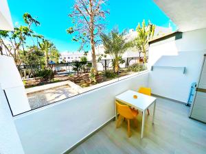 a balcony with a table and a view of a pool at Modern Studio with Pool & Terrace Playa de las Américas, Tenerife in Playa de las Americas