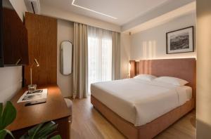 a hotel room with a bed and a desk and a bedroom at Pillow by the Sea in Thessaloniki