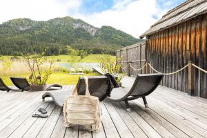 a deck with chairs and a dog sitting on it at Seehaus Verena in Weissensee