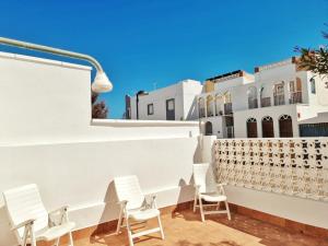 a row of chairs on a patio with white buildings at Casa REFUGIO DEL CABO, Cabo de Gata in El Cabo de Gata +45 photos