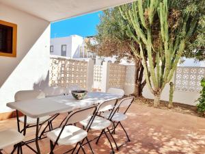 a table and chairs on a patio with a cactus at Casa REFUGIO DEL CABO, Cabo de Gata in El Cabo de Gata