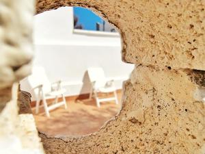 a hole in a wall with chairs in the background at Casa REFUGIO DEL CABO, Cabo de Gata in El Cabo de Gata
