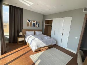 a bedroom with a bed and a large window at Maison 7 Residence in Obour