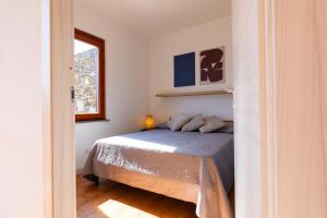 a small bedroom with a bed and a window at L10 Terrazza Ponente A breathtaking view in Stintino +25 photos