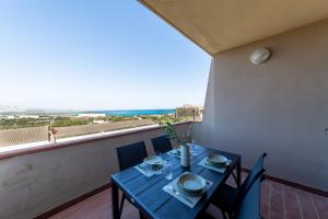 a table and chairs on a balcony with a view of the ocean at L10 Terrazza Ponente A breathtaking view in Stintino