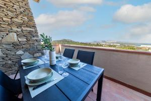 a blue table with plates and glasses on a balcony at L10 Terrazza Ponente A breathtaking view in Stintino