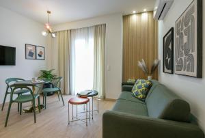 a living room with a green couch and a table at Pillow by the Sea in Thessaloniki