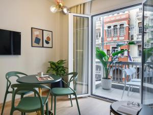 a dining room with a table and chairs and a window at Pillow by the Sea in Thessaloniki