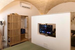 a living room with a tv on a wall at Suite Bobo in Monopoli