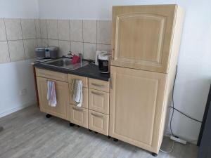 a small kitchen with a sink and a refrigerator at Auszeit im Vorharz in Wegeleben