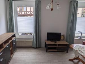 a bedroom with a bed and a desk and two windows at Auszeit im Vorharz in Wegeleben