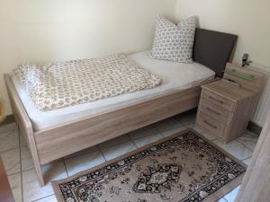 a bed with a wooden frame and pillows and a rug at Auszeit im Vorharz in Wegeleben