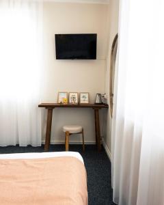 a room with a table with a television and a stool at La Villa Rose-Marie in Saint-Brevin-les-Pins