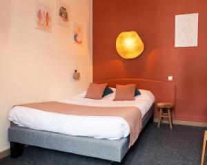 a bedroom with a bed with a yellow orb on the wall at La Villa Rose-Marie in Saint-Brevin-les-Pins