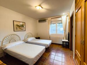 a hotel room with two beds and a window at Finca Bellavista de Gredos in Madrigal de la Vera +62 photos
