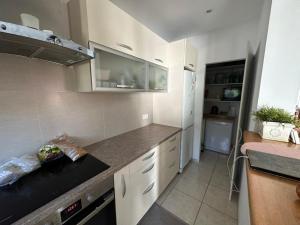 a kitchen with white cabinets and a black counter top at Casa Tineretului in Dej