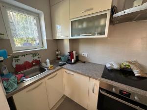 a kitchen with white cabinets and a sink and a window at Casa Tineretului in Dej