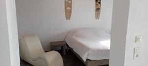 a small bedroom with a bed and a chair at Escapade Maritime in Dompierre-sur-Mer