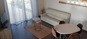 a living room with a couch and a table and chairs at Escapade Maritime in Dompierre-sur-Mer