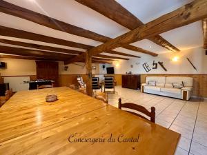 ein großer Raum mit einem Holztisch und einem Wohnzimmer in der Unterkunft Celles - Demeure de la Tourille in Celles