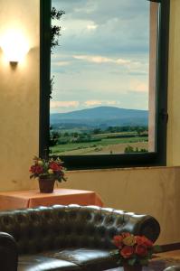 eine Ledercouch vor einem Fenster mit Aussicht in der Unterkunft Hotel Angiolino in Chianciano Terme