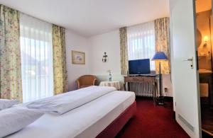a hotel room with a bed and a television at Flexibel Wohnen - BnoB in Füssen