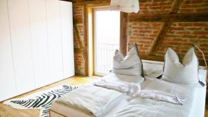 a bed with pillows on it in a room with a window at Design trifft Denkmal in Wangen im Allgäu