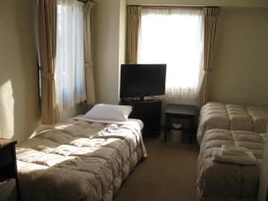 Postel nebo postele na pokoji v ubytování Mito Riverside Hotel