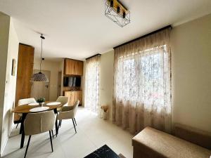 a living room with a table and chairs and a window at MEDA Apartman in Sárvár