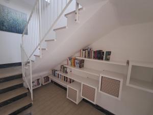 a staircase with a book shelf with books at Bouganvillea in Senigallia
