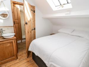 a bedroom with a white bed and a sink at Studio Bach in Beaumaris