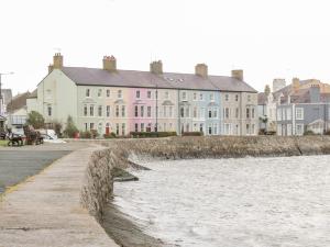 a row of houses next to a river with buildings at Studio Bach in Beaumaris