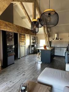 a large kitchen with a table and a counter in a room at Charmant loft industriel de 40m2 in Aubignan +3 photos