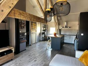 a large room with a kitchen with a table and a counter at Charmant loft industriel de 40m2 in Aubignan
