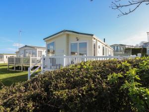a small white house with a white fence at Ocean Breeze Escape in Rochester