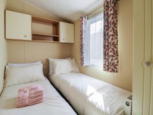 two beds in a small room with a window at Ocean Breeze Escape in Rochester