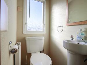 a bathroom with a toilet and a sink and a window at Ocean Breeze Escape in Rochester +16 photos