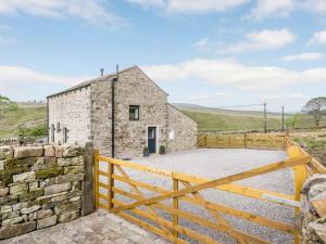 a stone cottage with a wooden fence and a gate at 2 Bed in Skipton oc-82602 in Buckden